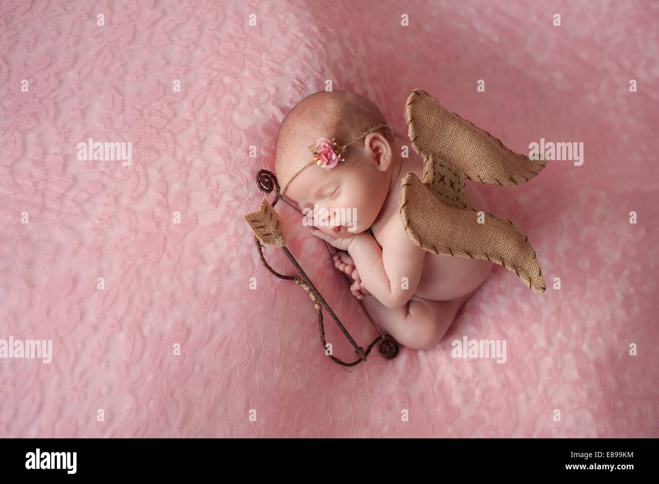 Portrait of a newborn baby girl wearing a Cupid costume. Stock Photo