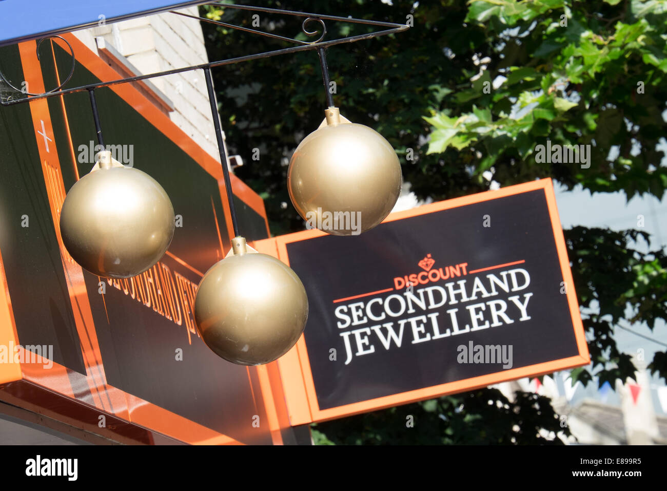 Three golden balls sign hanging outside a high street pawn shop & secondnand jewelry store in Swindon, Wiltshire, UK Stock Photo