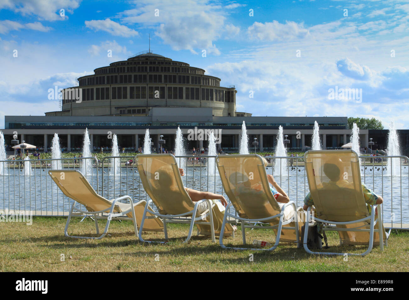 People on deckchairs at the Centennial Hall (designed by Max Berg, built in 1911–1913, listed on UNESCO Site in 2006) in Wroclaw Stock Photo