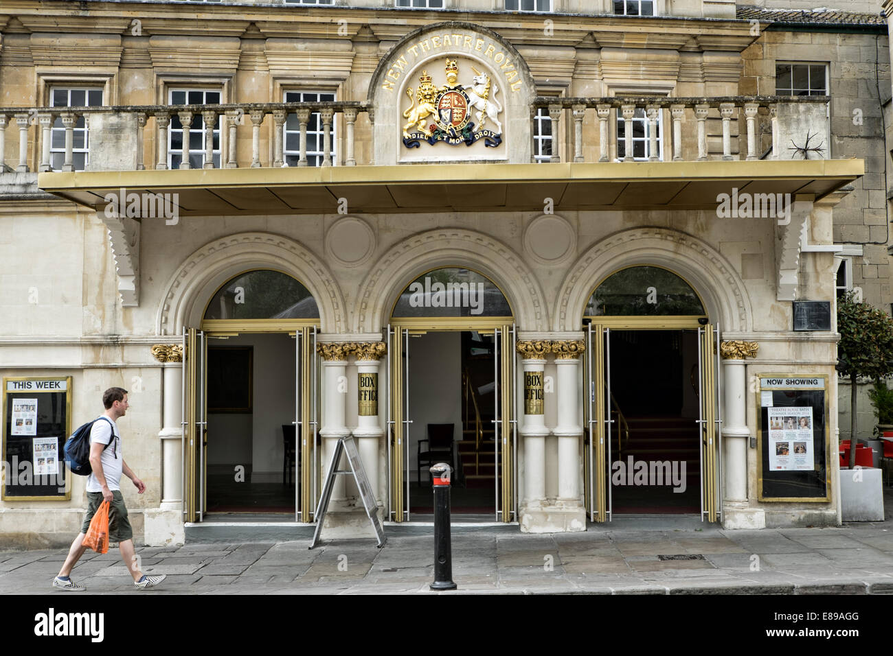 A pedestrian walking past the entrance to the historic New Theatre Royal in the world heritage city of Bath, Somerset, UK Stock Photo