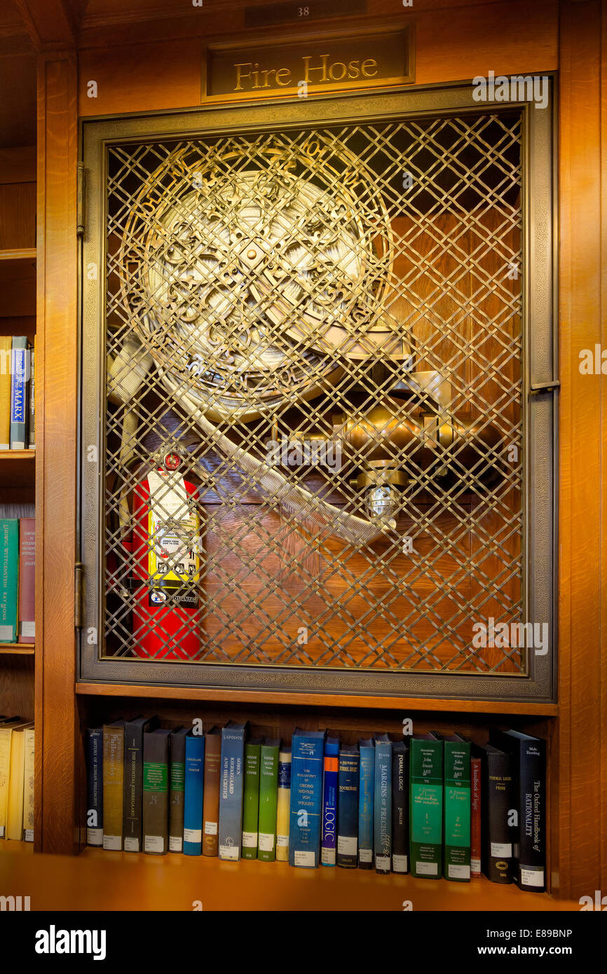 Vintage canvas fire hose alongside a modern fire extinguisher at the main branch of the New York Public Library in New York City. Stock Photo