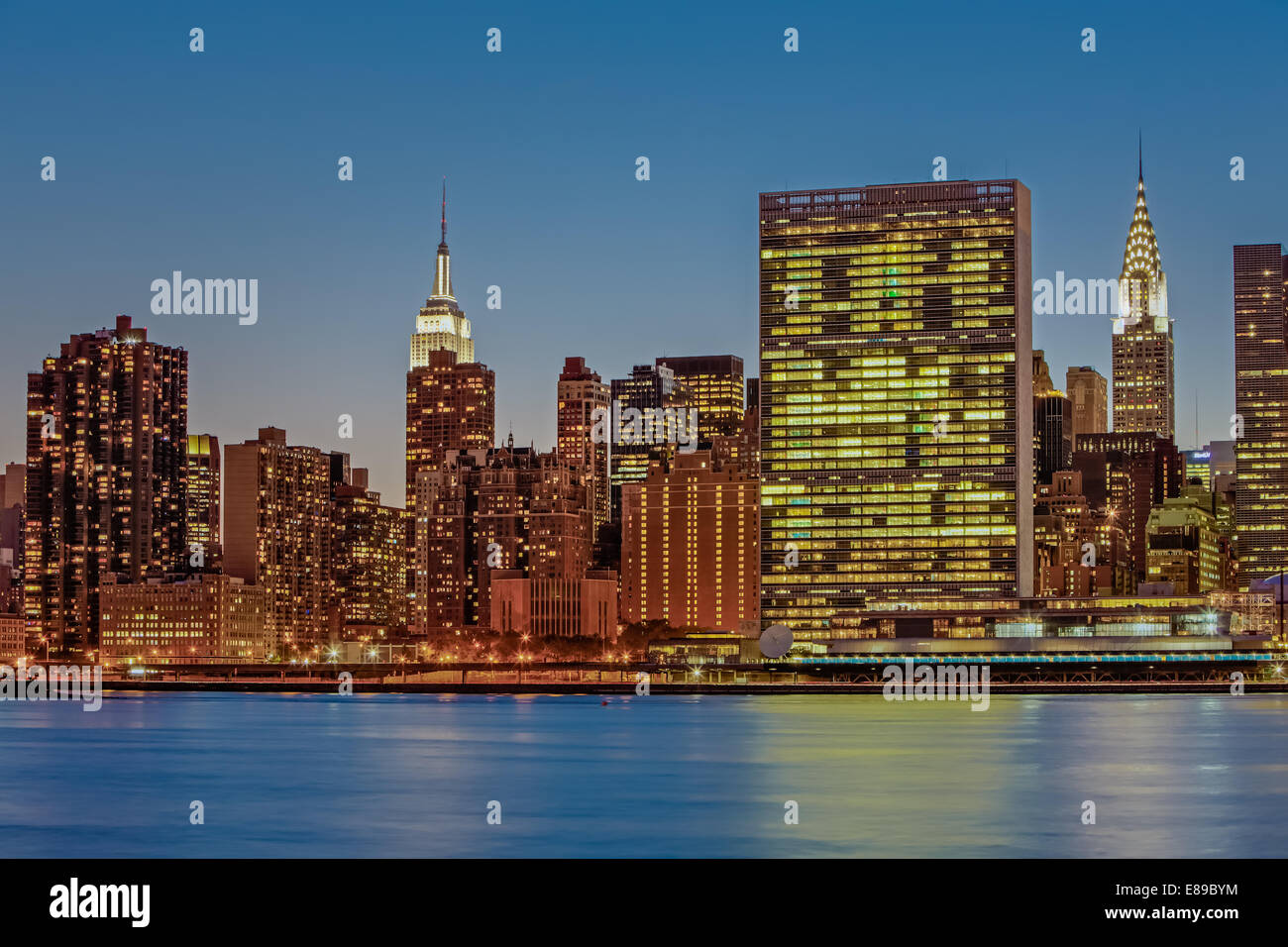 New York City Landmarks - Midtown Manhattan New York City skyline view of the Empire State Building, The United Nations and the iconic Chrysler Building. Photographed during the blue hour of twilight. Stock Photo