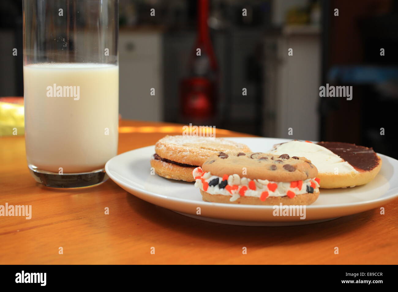 A plate of black and white, peanut butter and whoopie cookies with milk ...