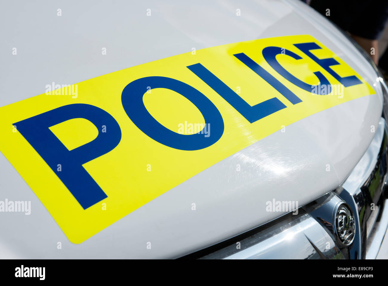 The word police on a sign on the hood of a white British Vauxhall Police car Stock Photo