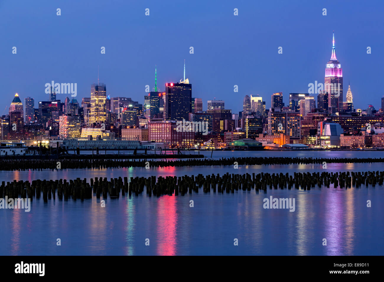 Empire State Building lights up to mark the Easter holiday in pastel fades colors, during the blue hour at twilight. Stock Photo