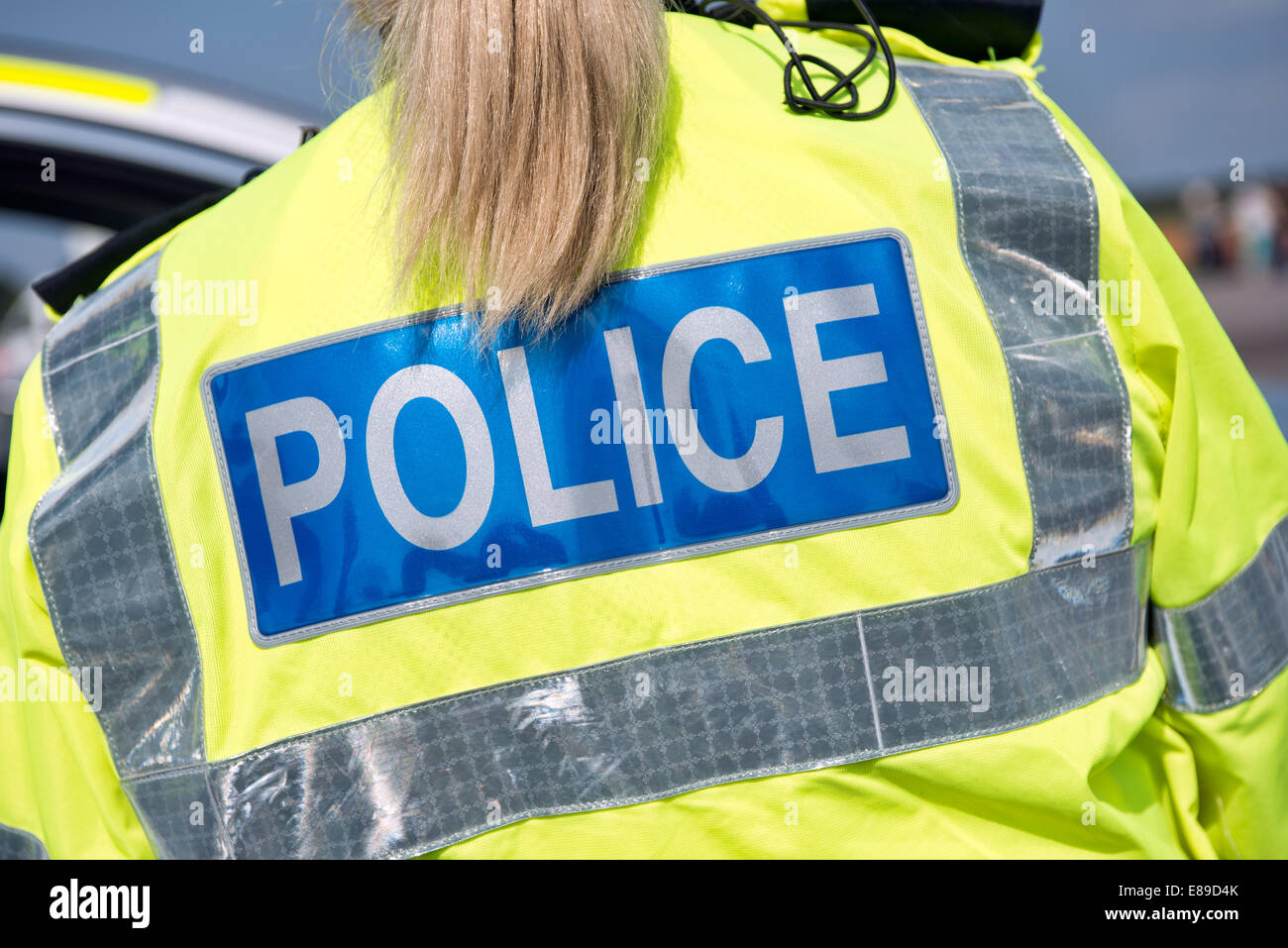 A female British police officer wearing a uniform hi vis reflective safety jacket Stock Photo