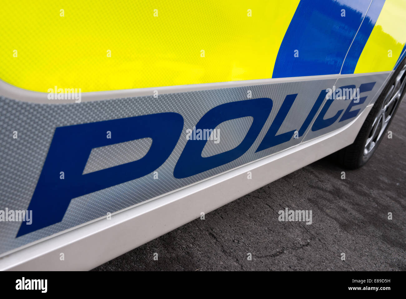 The word police on a reflective sign on the side of a white British Police car Stock Photo