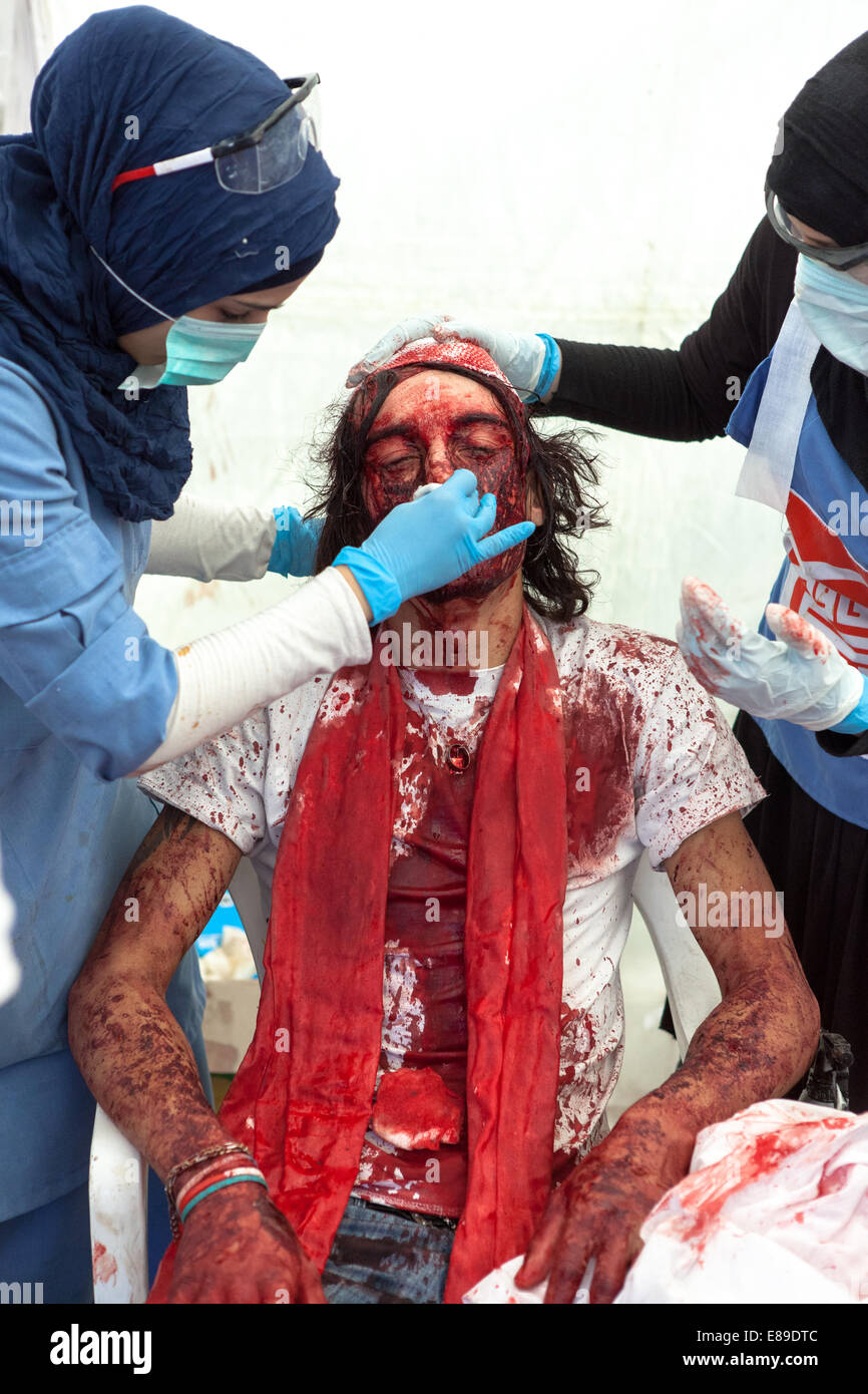 Shiite Muslim man, covered in his own blood, receiving medical attention, on Ashura Day in Nabatieh, Lebanon. Stock Photo