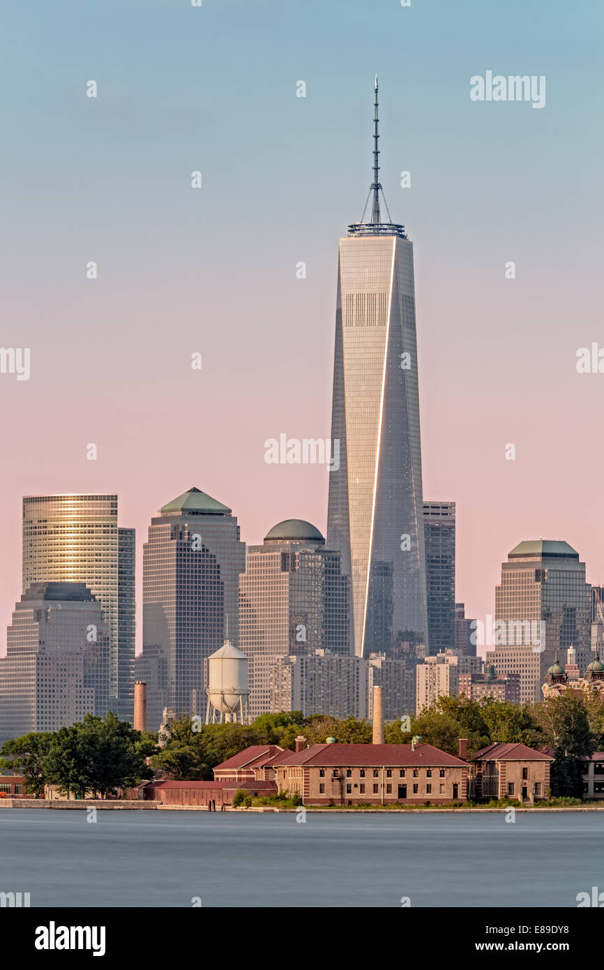 One World Trade Center commonly referred to as The Freedom Tower along with other skyscrapers in the Financial District and Battery Park. Also seen is Ellis Island another symbol of freedom in the foreground. Stock Photo