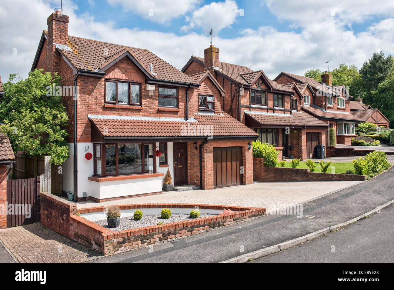 The front exterior of a modern red brick detached UK family home built