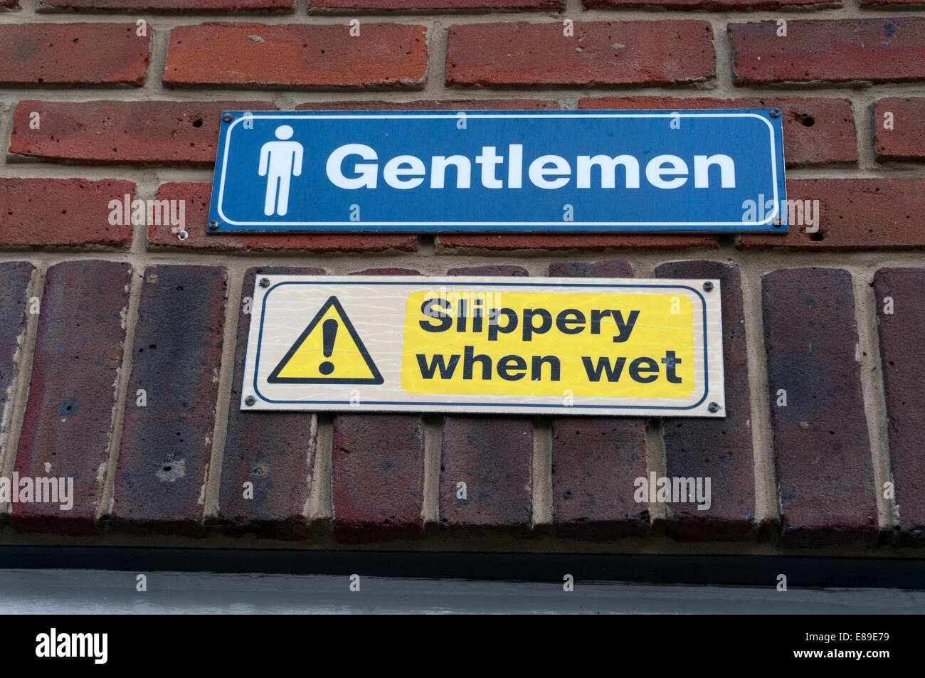 Amusing sign above Gents toilets, Chichester, West Sussex Stock Photo