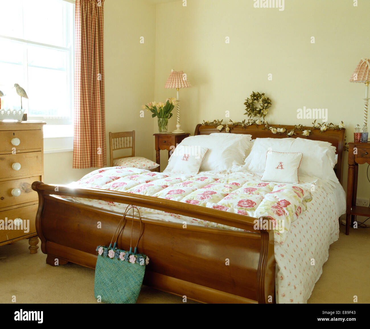Old fashioned rose patterned eiderdown and white pillows on sleigh bed
