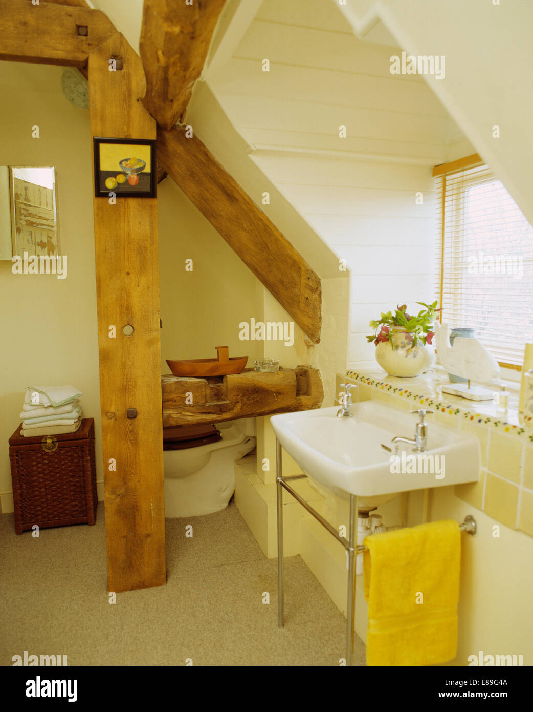 White basin below window in cream bathroom in converted stable with