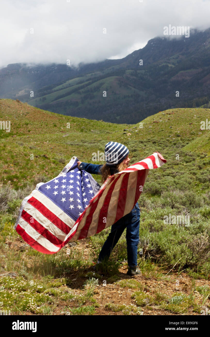 Girl with American flag in field Stock Photo