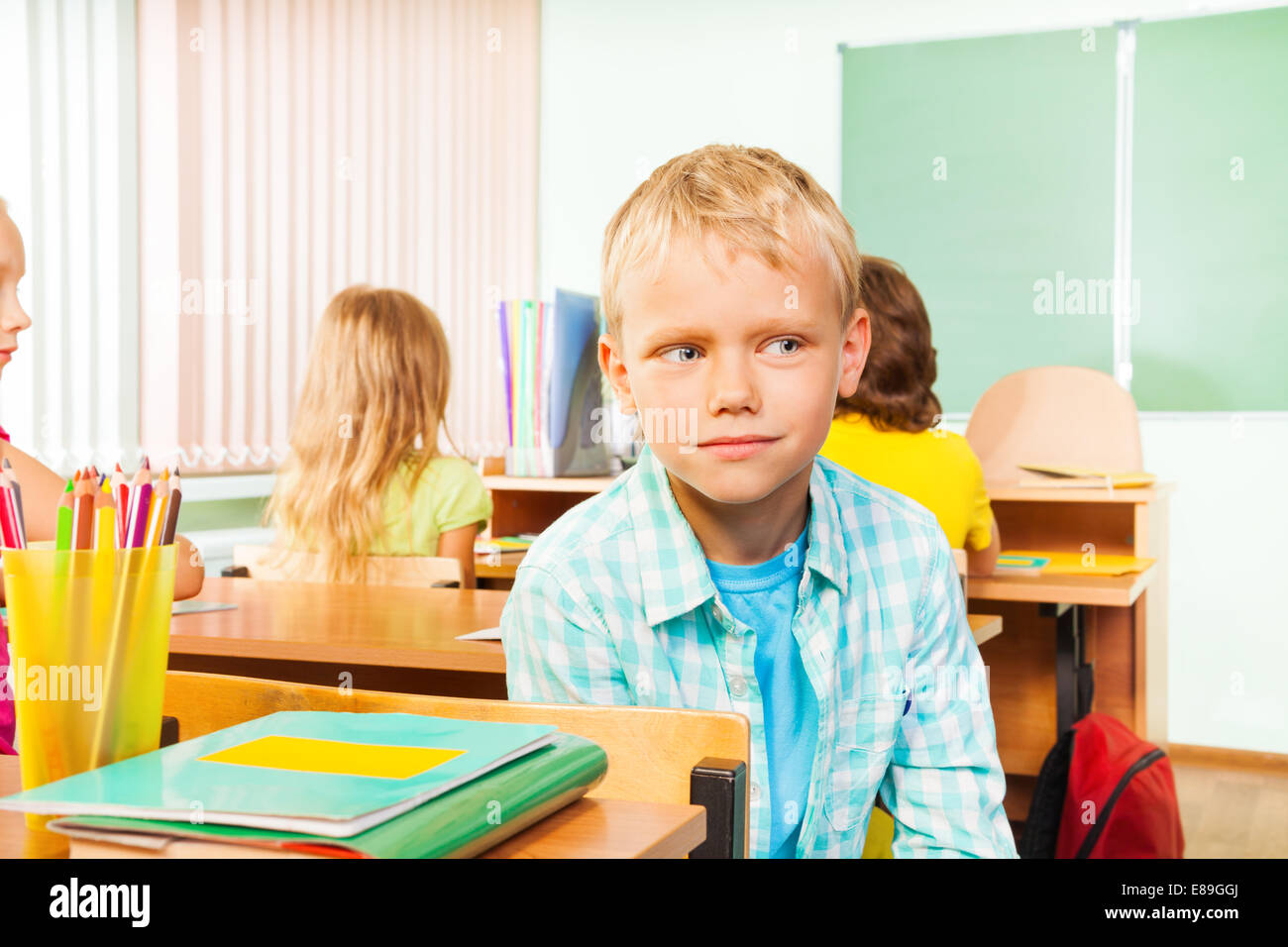 Boy sitting in school class and looking right Stock Photo