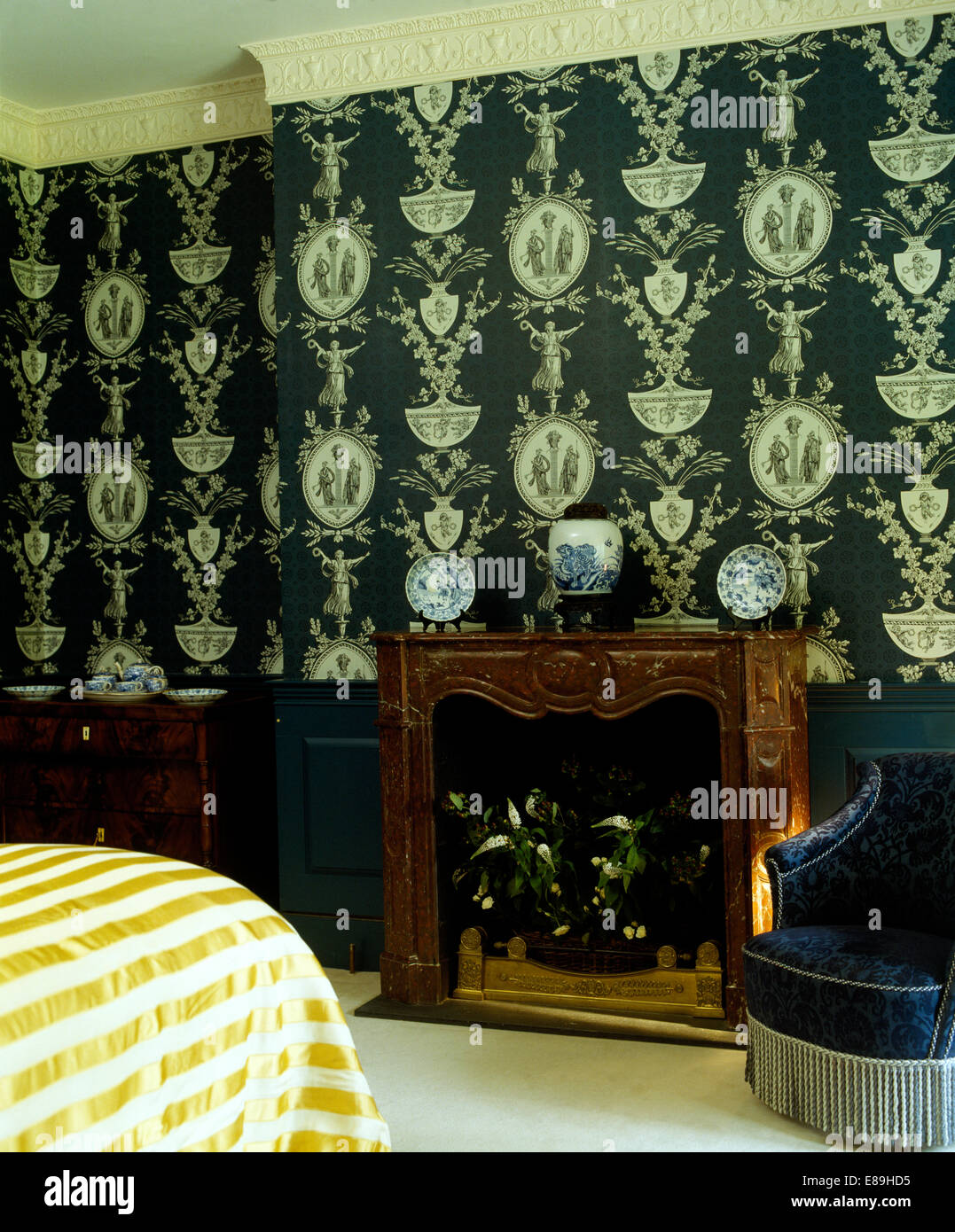 Black+white Georgian-style wallpaper on wall above fireplace in bedroom