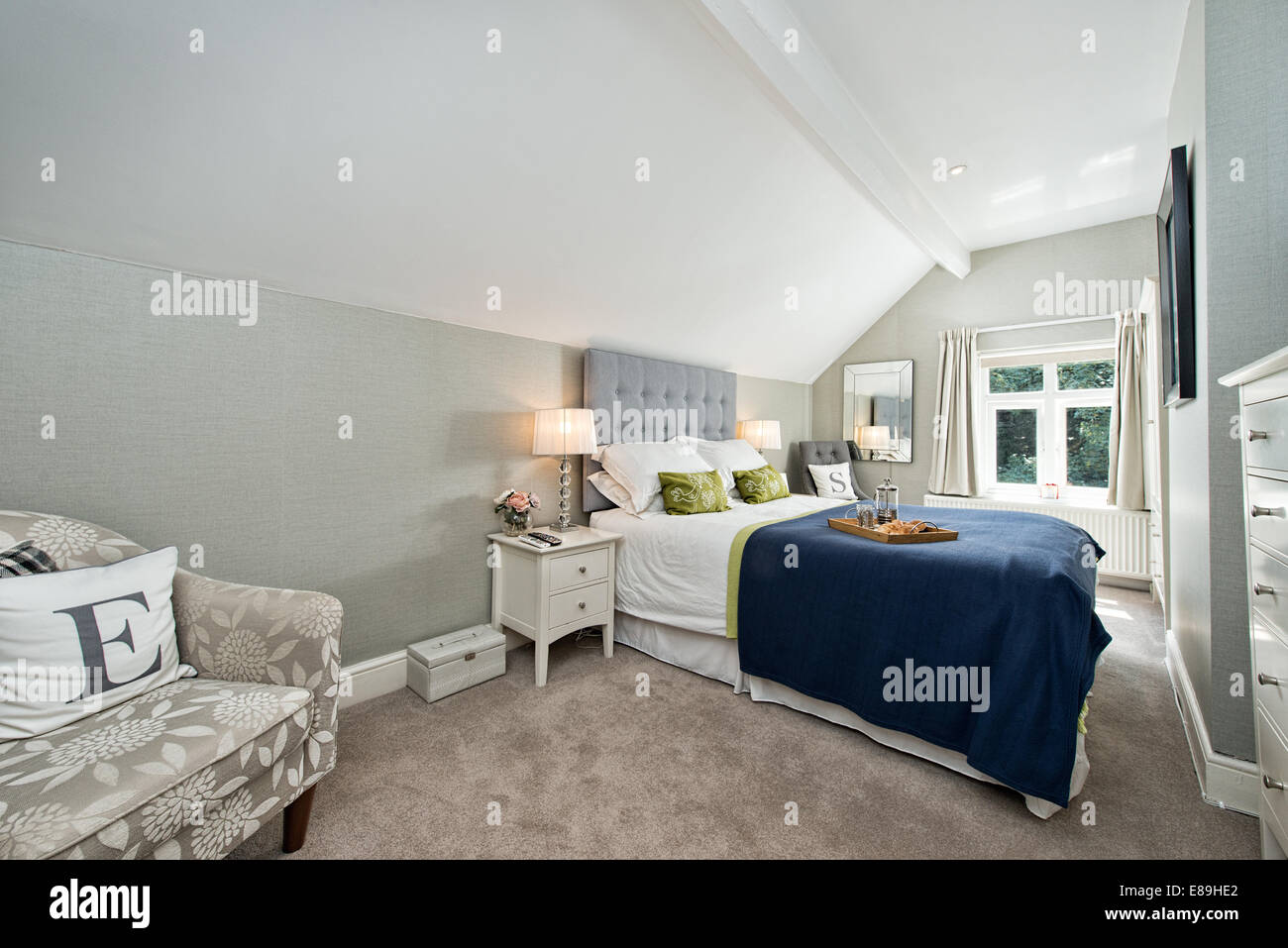 Breakfast in bed in a comfortable contemporary double bedroom decorated in blues & greys Stock Photo