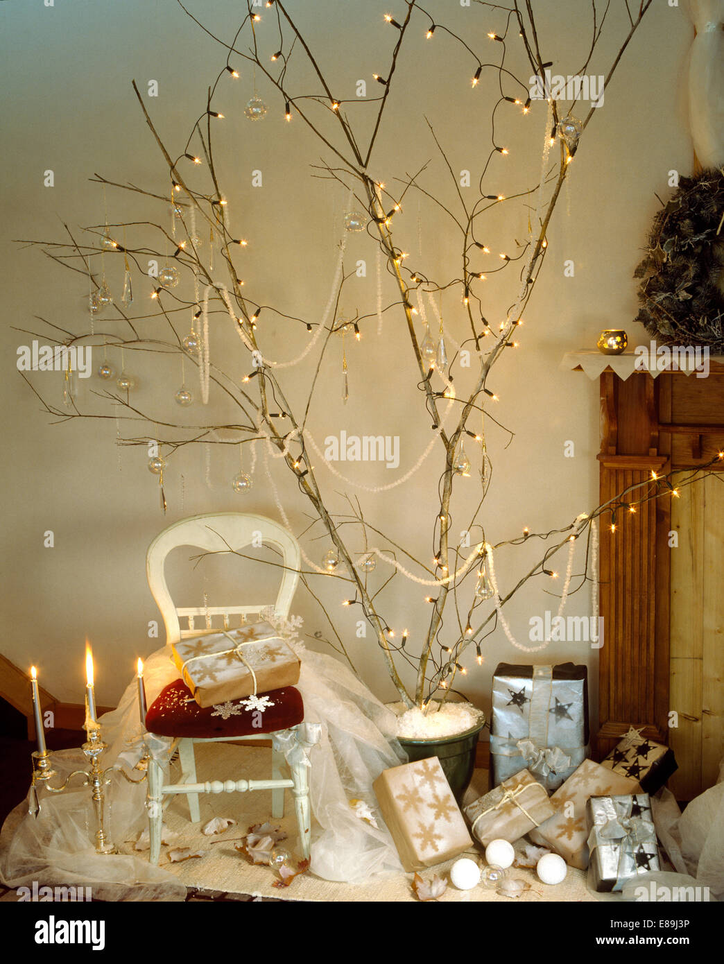 Home-made Christmas tree of fairy lights on tall branches above Christmas  presents Stock Photo - Alamy