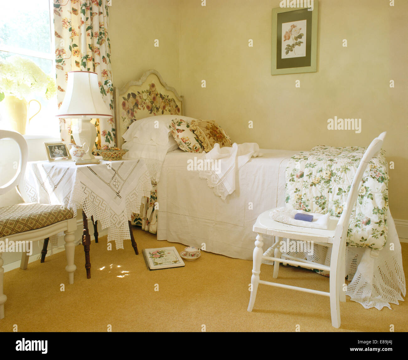 White painted chair beside single bed with white bedcover in