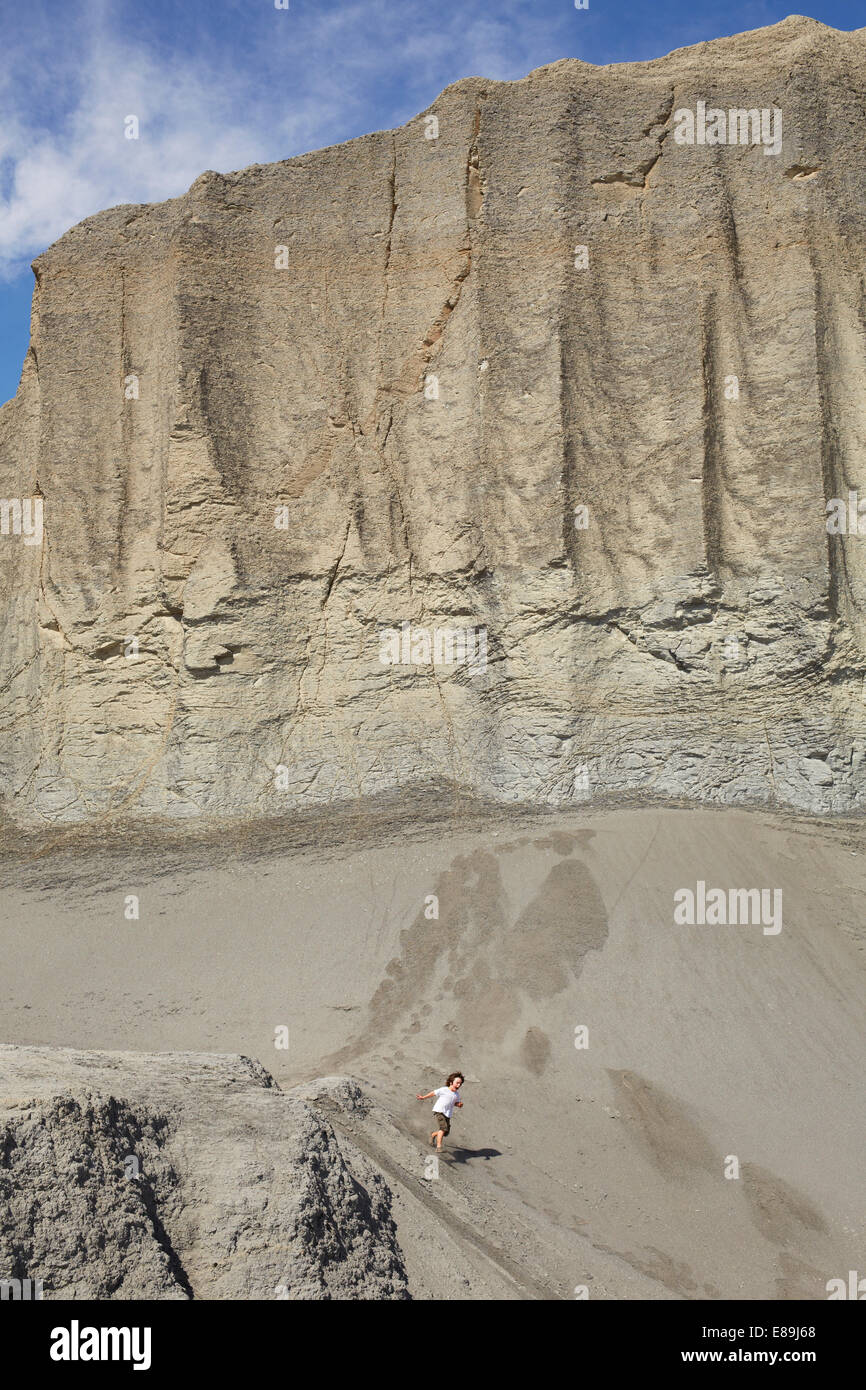 Boy running down giant sand dune Stock Photo