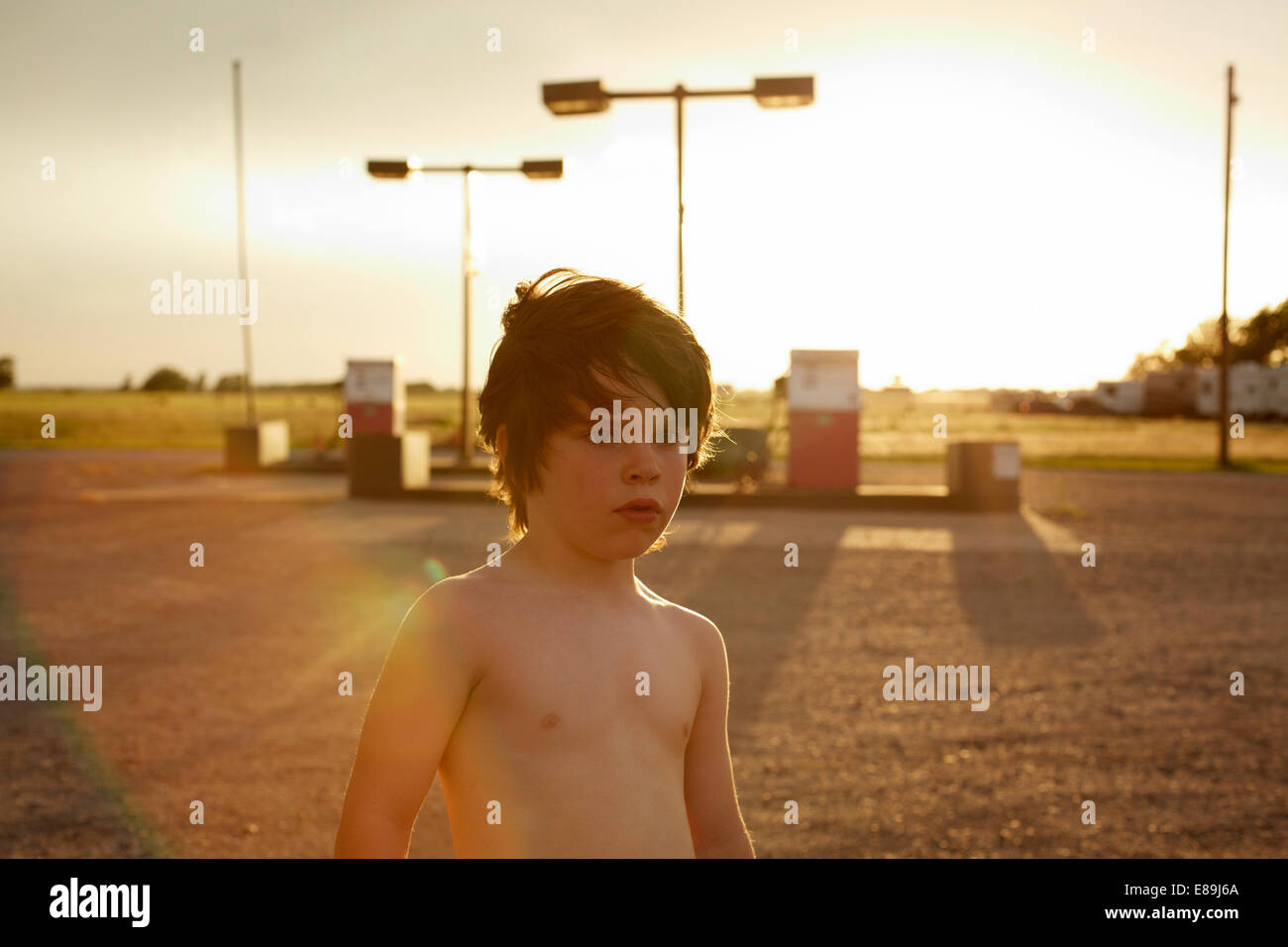 Shirtless boy at gas station Stock Photo