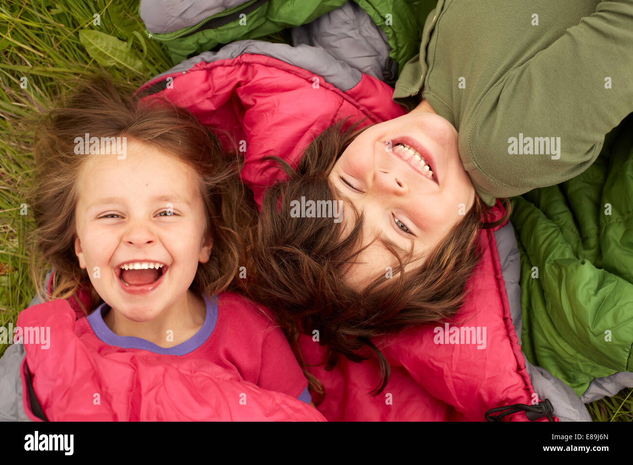Laughing kids laying on sleeping bags Stock Photo