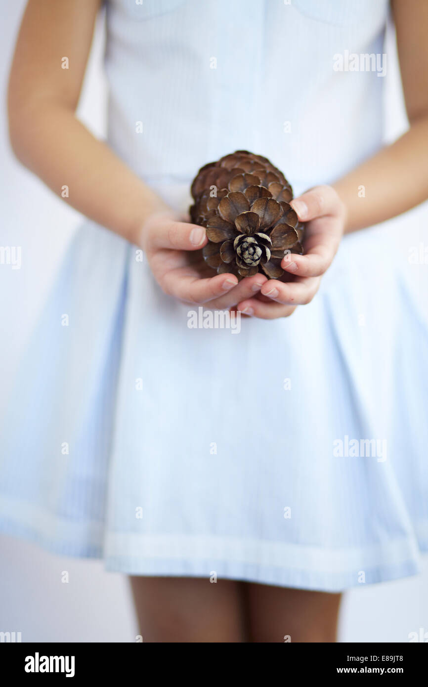 Girl holding large pinecone Stock Photo