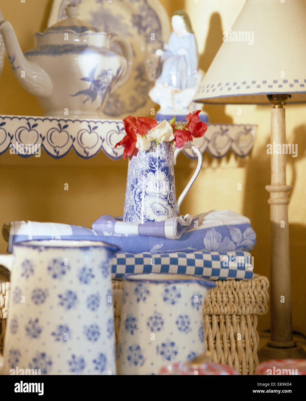 Close-up of blue+white jugs below shelves with decorative blue+white painted edging Stock Photo