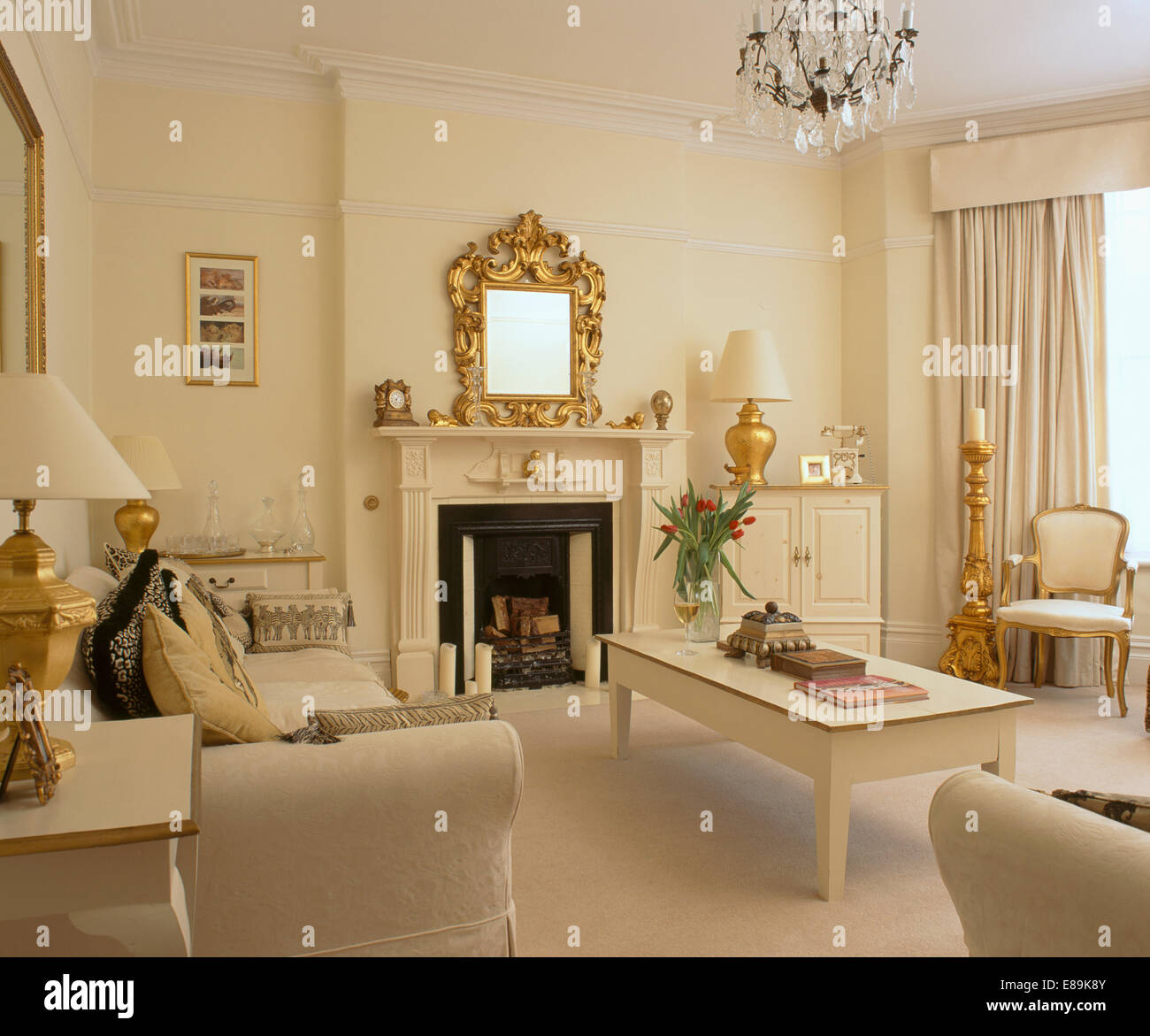 Cream living room with cream table and sofas and gold accessories Stock