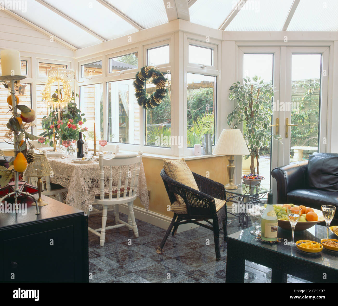 Black wicker chair and leather sofa in conservatory living and dining