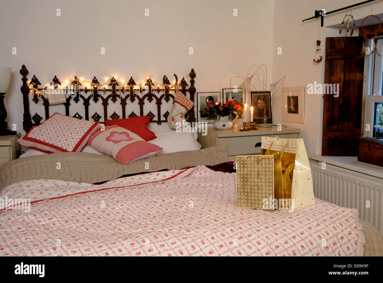 Cottage Bedroom With Wrapped Christmas Presents On Bed With Stock