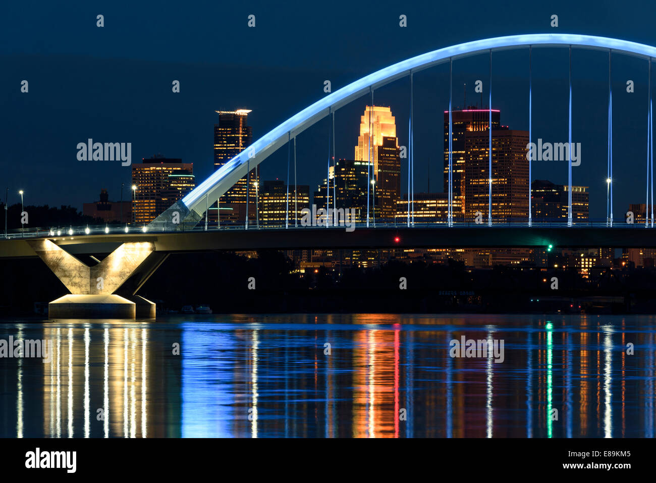 Lowery Avenue bridge with blue lighting over the Mississippi River and Minneapolis skyline at night. Stock Photo