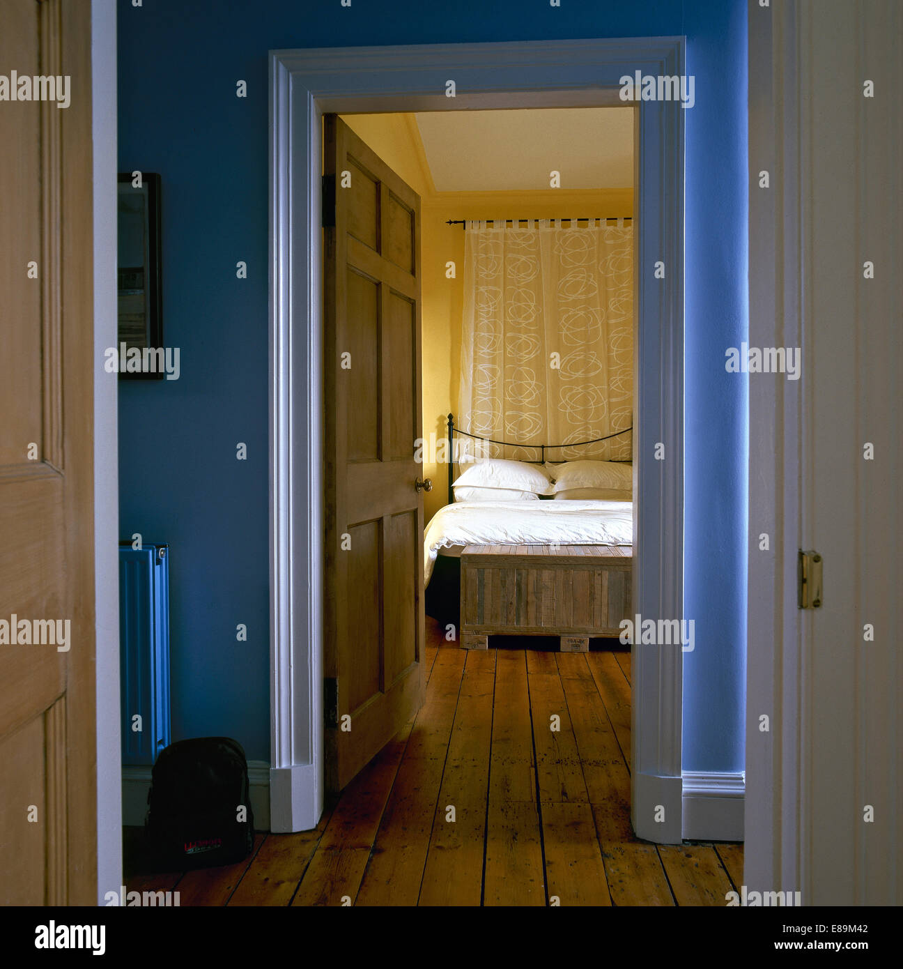Open door on landing with view of traditional bedroom with wooden flooring Stock Photo