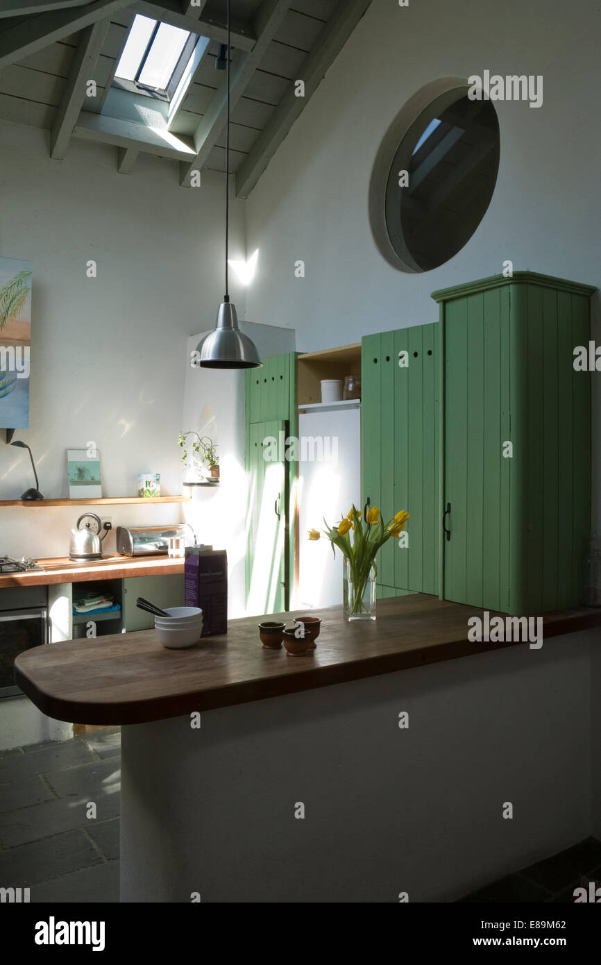 Peninsula unit breakfast bar in country kitchen and green fitted units