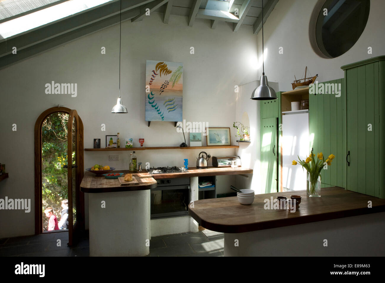 Peninsula unit breakfast bar in country kitchen with green fitted unit