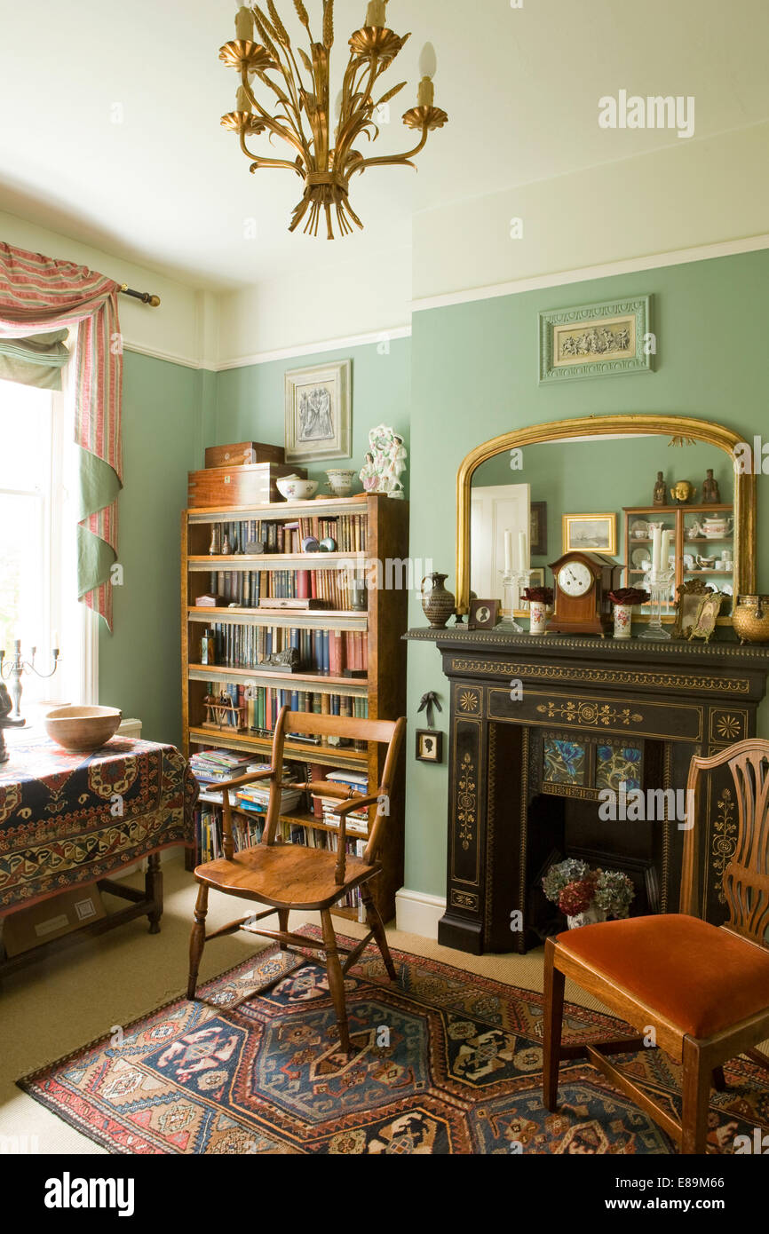 Gilt mirror above Edwardian fireplace in traditional green dining room Stock Photo