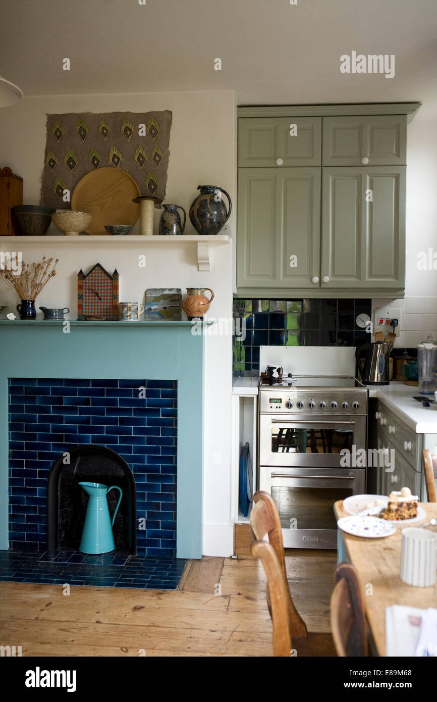 Country Kitchen With Blue Tiled Fireplace And Small Gas Cooker Stock Photo Alamy