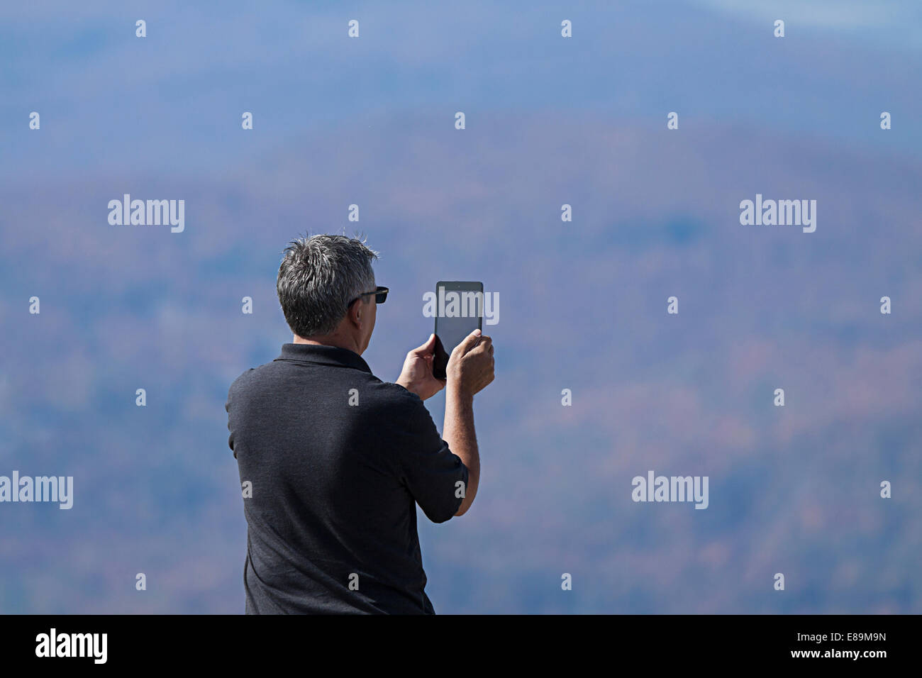 Man filming with a tablet indian summer on Mont Tremblant Stock Photo