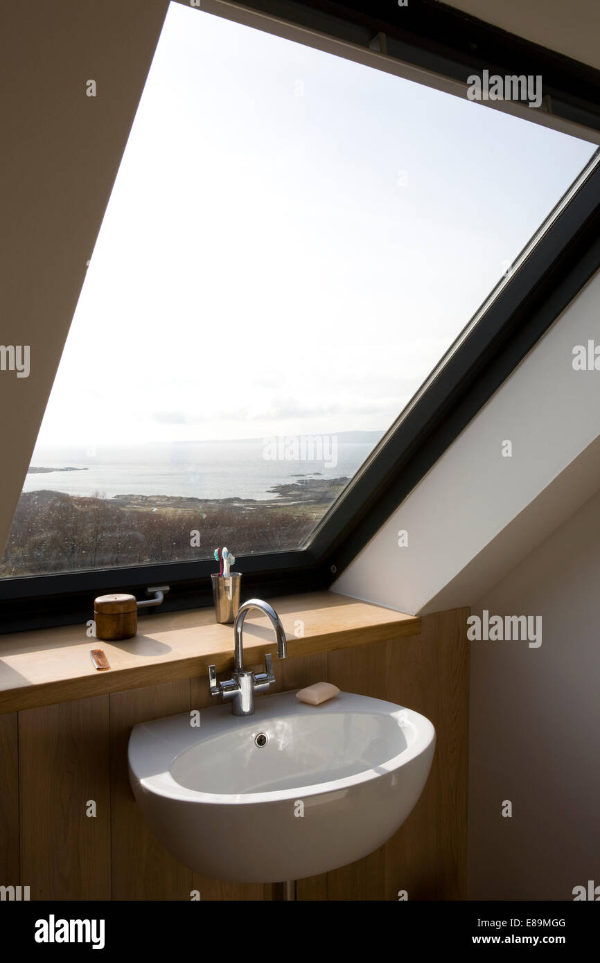 Basin below Velux window with view of the countryside in loft bathroom