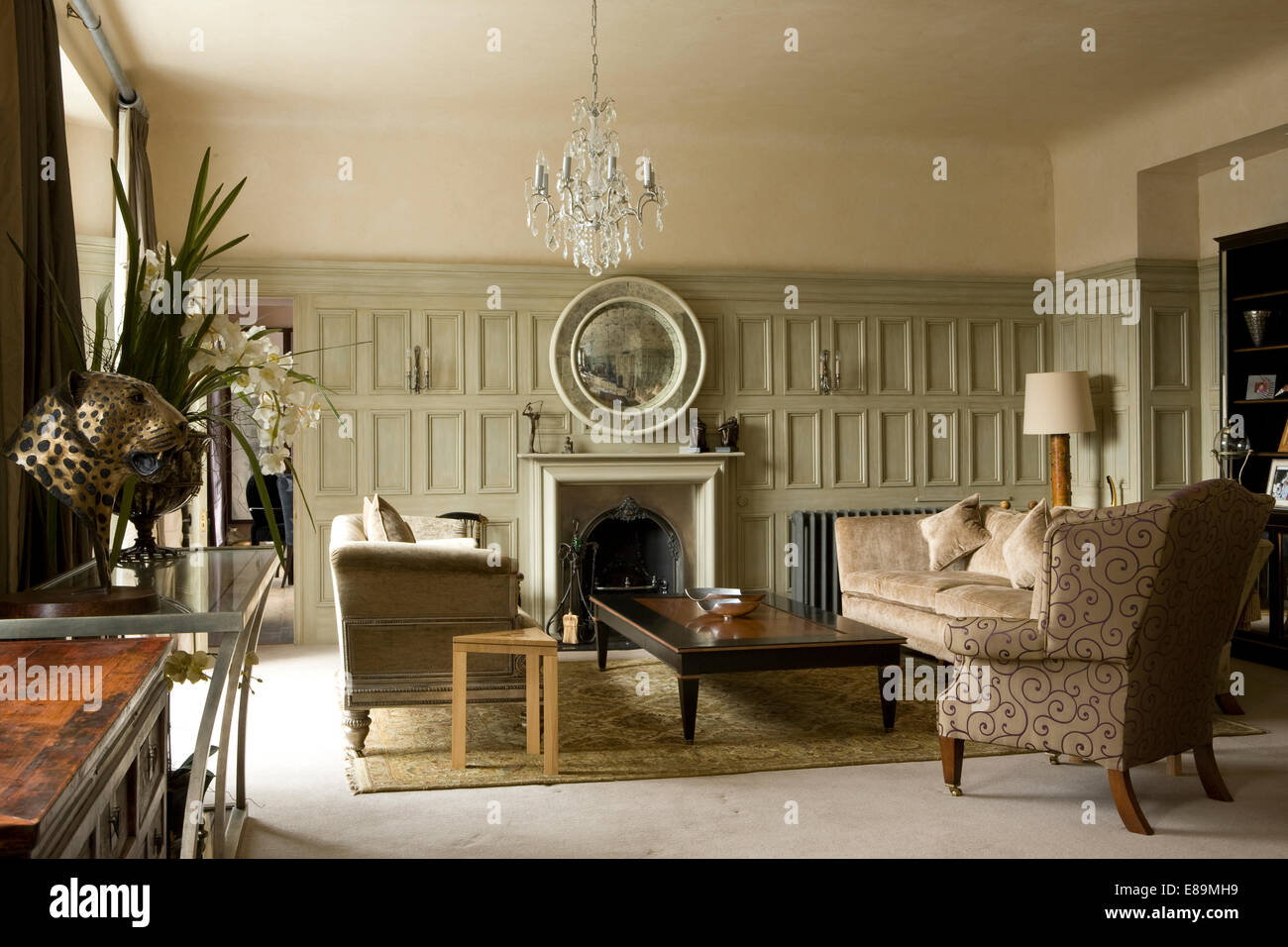 Pale grey panelled walls in country sitting room with cream sofas and