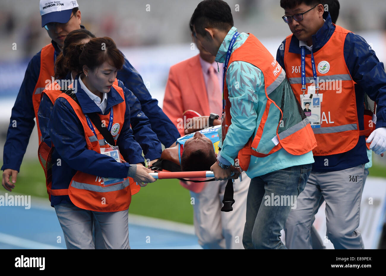 Incheon, South Korea. 3rd Oct, 2014. Bat Ochir Ser Od (C) of Mongolia is carried off the runway after the men's marathon match of athletics at the 17th Asian Games in Incheon, South Korea, Oct. 3, 2014. Bat Ochir Ser Od got the fourth place with 2 hours 13 minutes and 21 seconds. © Ling Yiguang/Xinhua/Alamy Live News Stock Photo