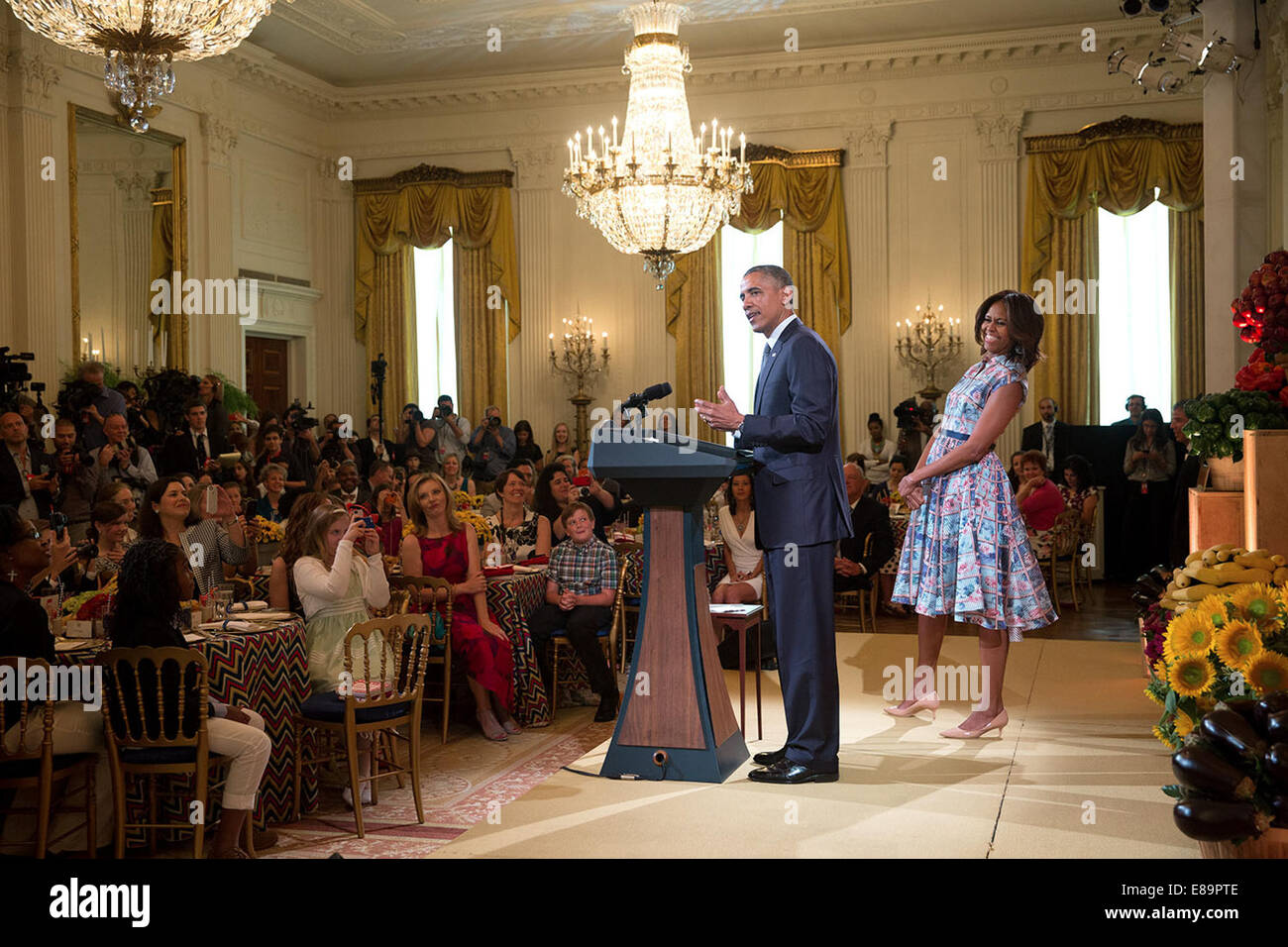 President Barack Obama joins First Lady Michelle Obama onstage for a surprise visit during the Kids' State Dinner in the East Room of the White House, July 18, 2014. Stock Photo