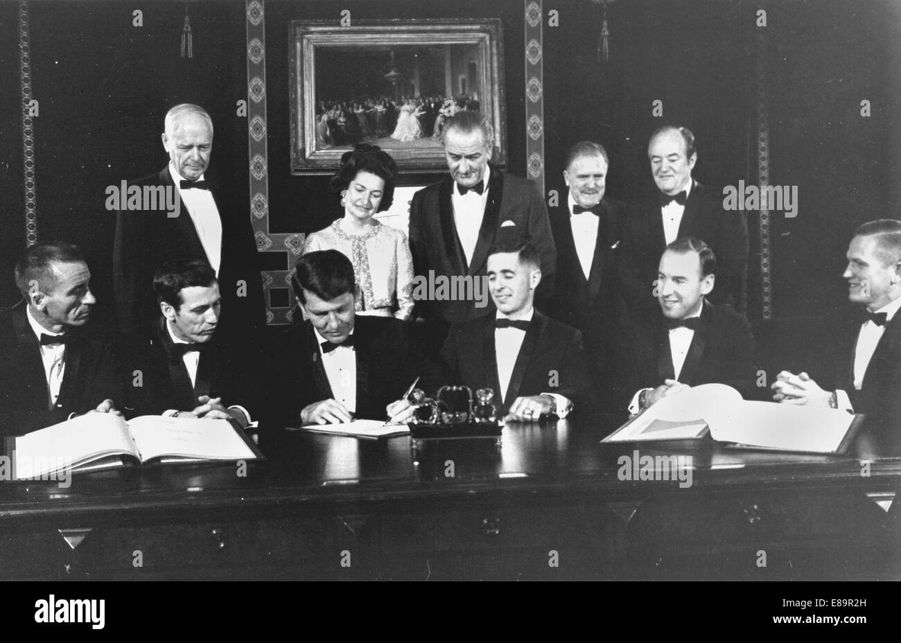 Apollo 7 and 8 flight crews sign a commemorative document to be hung in the Treaty Room of the White House honoring the occasion. Those signing are from left to right: Apollo 7 Astronauts: Walter Cunningham, Donn F. Eisele, and Walter M. Schirra. Apollo 8 Astronauts: William A. Anders, James A. Lovell, Jr., and Frank Borman. Standing are: Charles A. Lindbergh (also a signer) Lady Bird Johnson President Lyndon B. Johnson NASA Administrator James E. Webb, Vice President Hubert H. Humphrey.   Image # : 68-H-1300  Date: December 3, 1968 Stock Photo