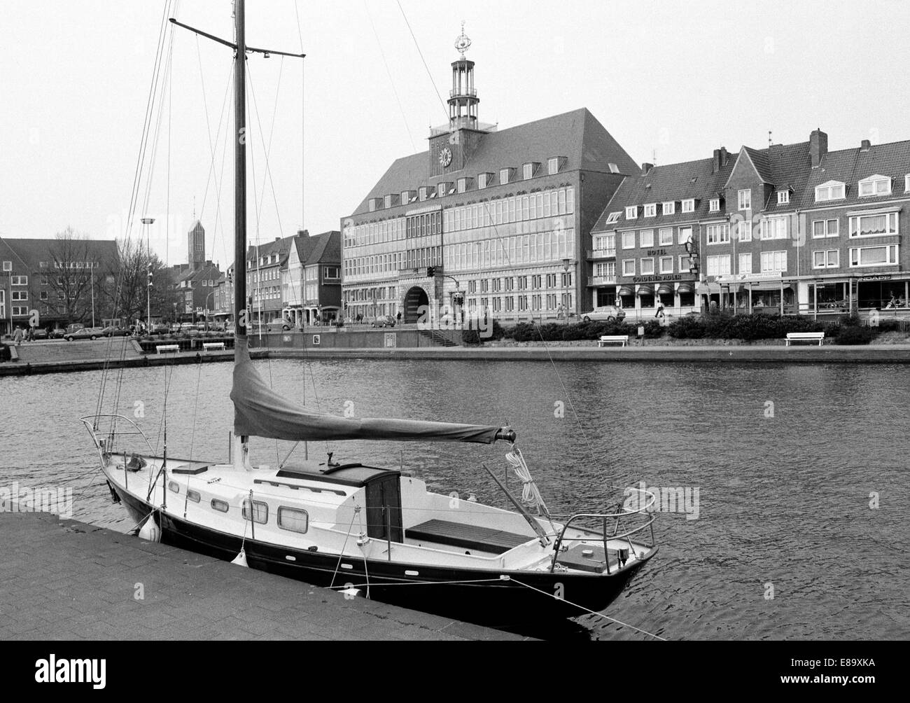 Achtziger Jahre, Segelboot an Liegestelle im Ratsdelft, dahinter das Emder Rathaus, Emden, Ostfriesland, Niedersachsen Stock Photo