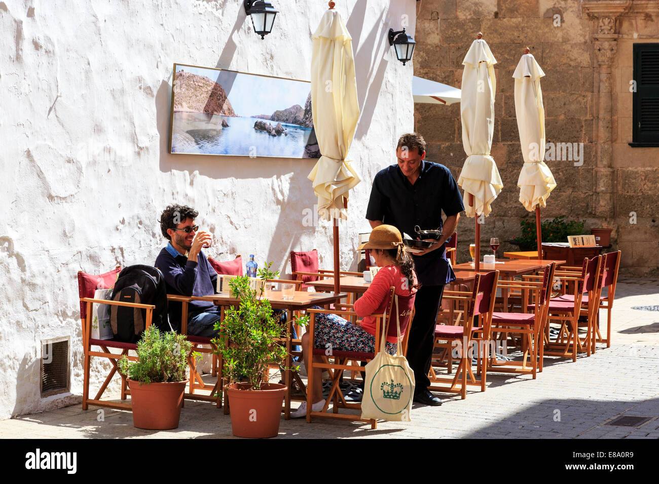 Man and woman being served at a small cafe, Ciutadella, Menorca, Spain Stock Photo