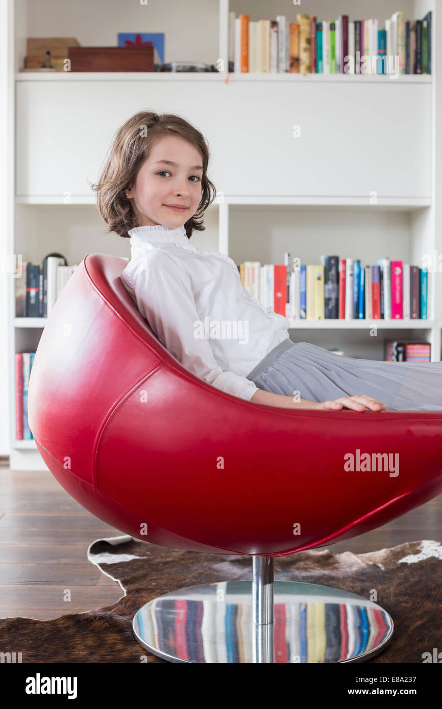 Portrait of girl sitting on chair, smiling Stock Photo - Alamy