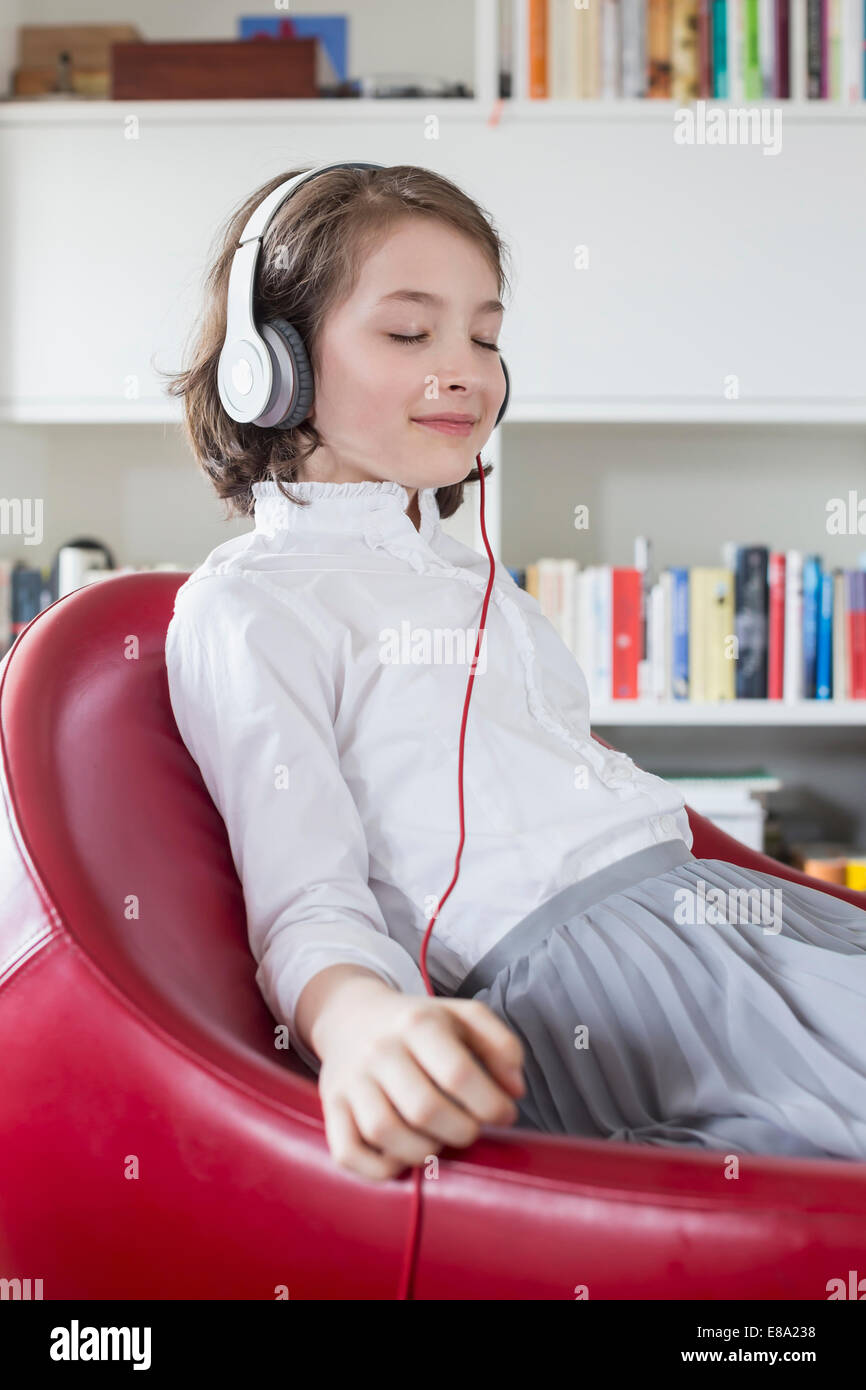 Girl sitting on chair and listening music with headset Stock Photo Alamy
