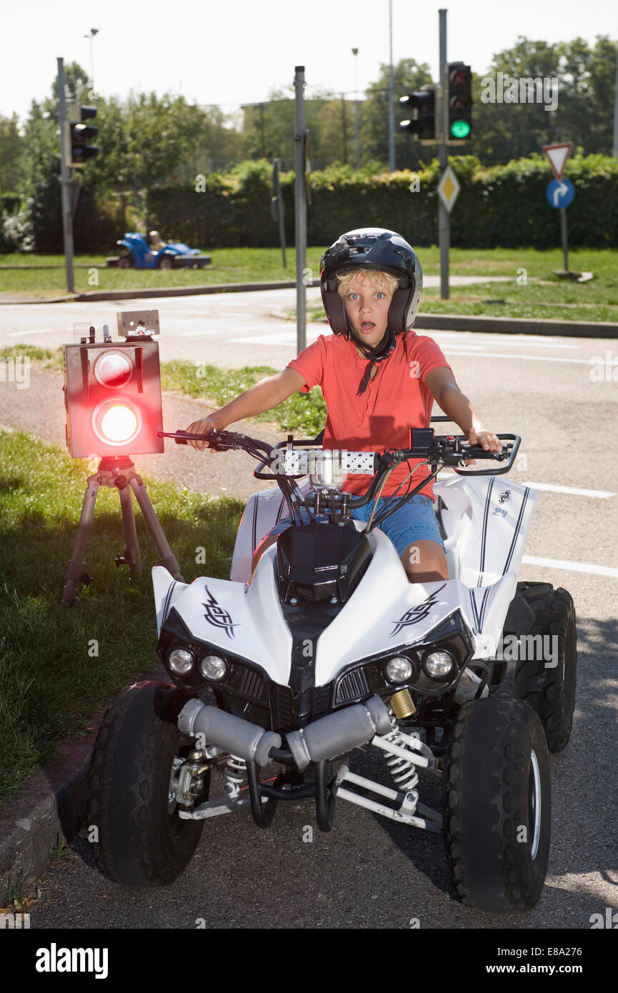 Boy with quadbike on driver training area with speed trap Stock Photo