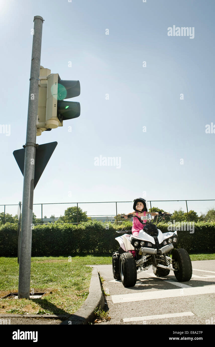 Girl with quadbike waiting at traffic light on driver training area Stock Photo