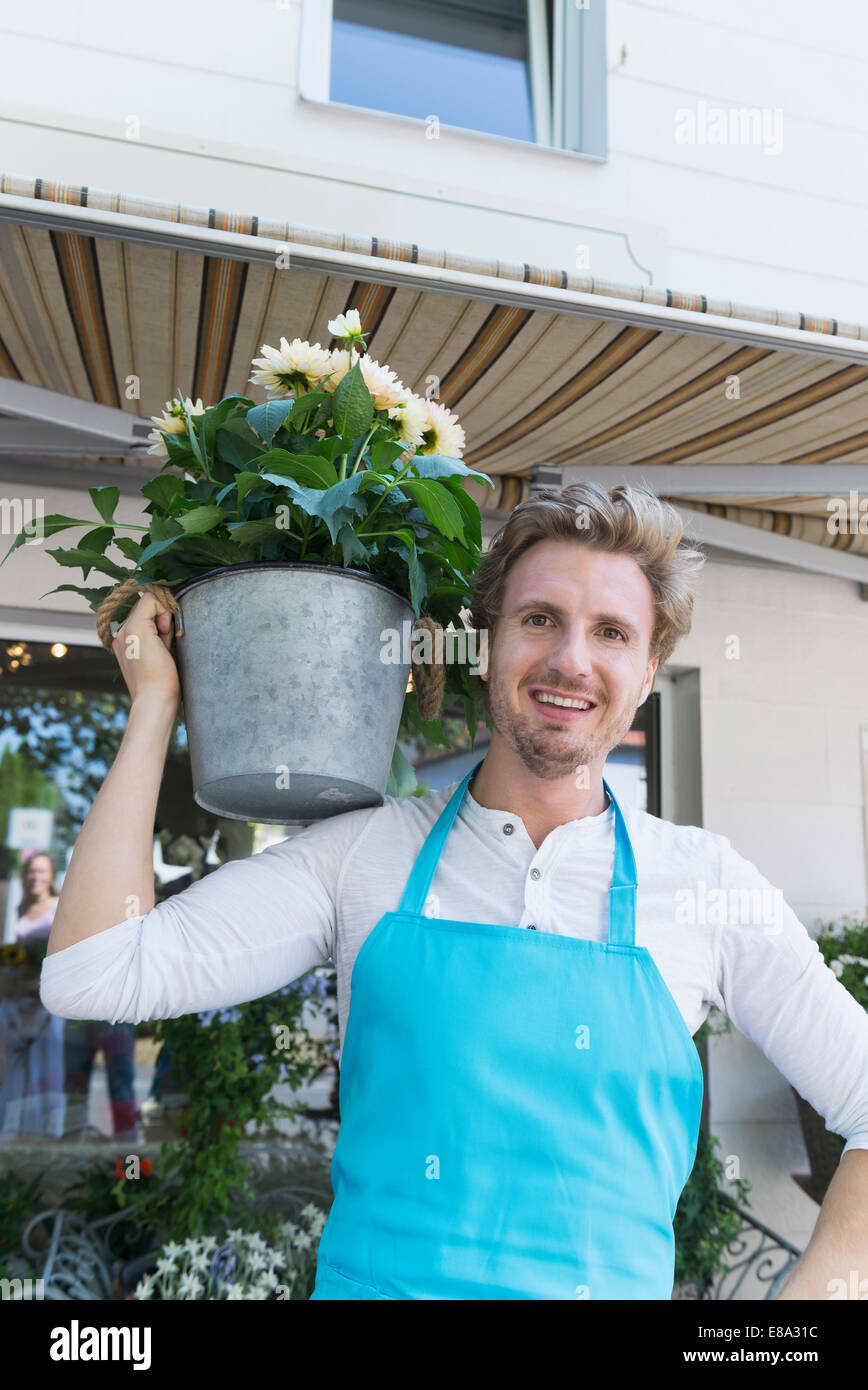 Portrait of mid adult man holding potted plant of flower, smiling Stock ...